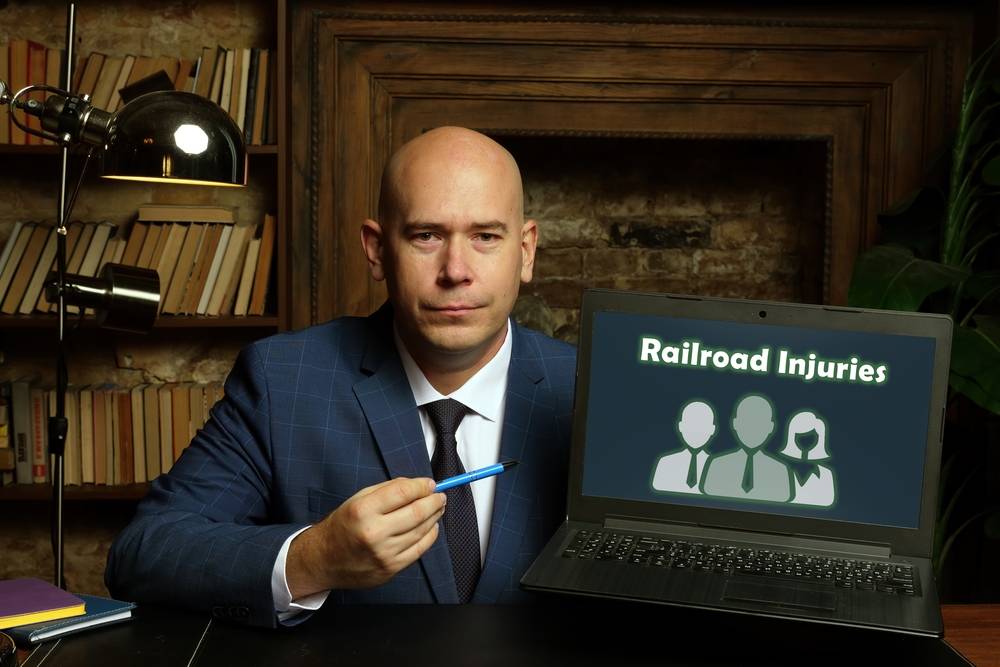 laptop in a hand with phrase railroad Injuries
